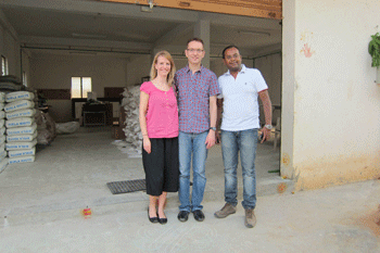 Lane_Jeff_Ajaay three people standing in front of concrete block shop with bags of cement